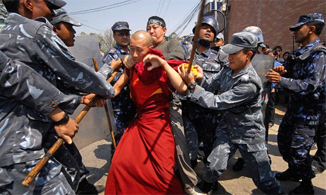 La polizia nepalese bastona un monaco tibetano.