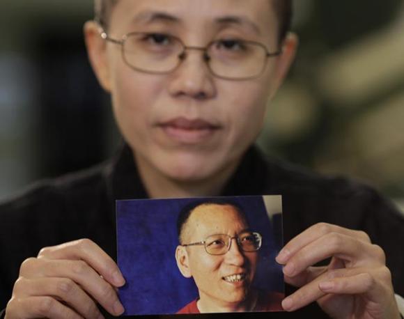Liu Xia, la moglie del dissidente cinese Liu Xiaobo, mostra la foto del marito tuttora incarcerato.