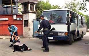 una tibetana cerca di fermare l’autobus sul quale sono caricati i tibetani per essere riportati oltre frontiera