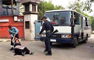 una tibetana cerca di fermare l’autobus sul quale sono caricati i tibetani per essere riportati oltre frontiera