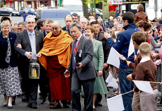 Richard Moore regge con Sua Santità il Dalai Lama la fiamma di Santa Brigida mentre viene accolto il 13 aprile 2011 dai bambini delle scuole di Kildare in Irlanda. Foto / Tenzin Taklha / OHHDL
