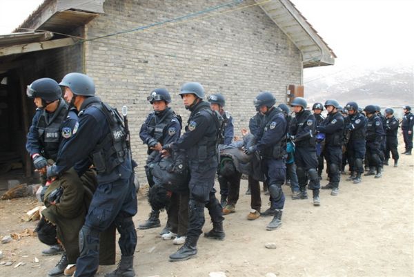 tib-prig Prigionieri tibetani con le mani legate dietro la schiena costretti a piegarsi verso terra.