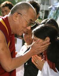 Sua Santità il Dalai lama impartisce la benedizione toccando la testa di una giovane tibetana.