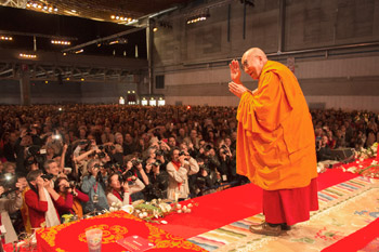His Holiness the Dalai Lama greeting the audience before the start of his teachings at the Forum Fribourg in Fribourg, Switzerland, on April 13, 2013. Photo/Manuel Bauer