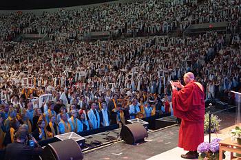 His Holiness the Dalai Lama acknowledging the 11,000 members of the audience wearing white silk scarves at the end of his talk at Veterans Memorial Coliseum in Portland, Oregon on May 11, 2013. Photo/Jeremy Russell/OHHDL