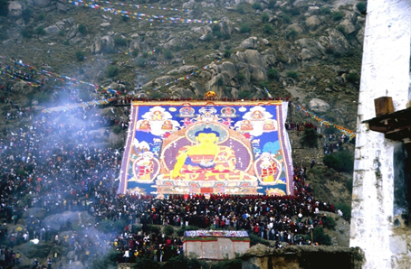 Esibizione di tangka (dipinto votivo su tela) durante celebrazione nel monastero di Drepung
