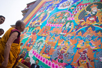 His Holiness the Dalai Lama looking at a huge appliqué thank of Guru Rinpoche hanging from Sera Jey Monastery as he arrives for the fifth day of his teaching in Bylakuppe, Karnataka, India on December 29, 2013. Photo/Tenzin Choejor/OHHDL
