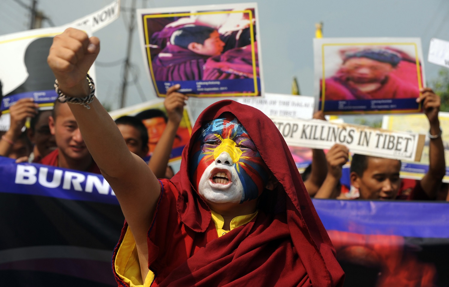 A Buddhist monk with the Tibetan flag painted on his face, in Siliguri, India, November 2011, protests in solidarity with dozens of monks who self-immolated in Tibetan parts of China to draw attention to their opposition to Beijing’s repression of indigenous culture.